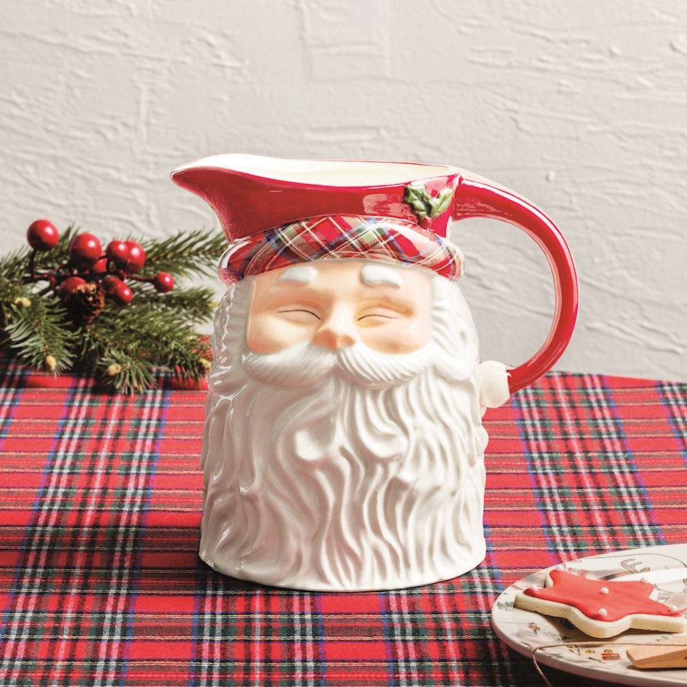 Ceramic Santa Claus head pitcher with a tartan plaid hat band set on a red plaid tablecloth.
