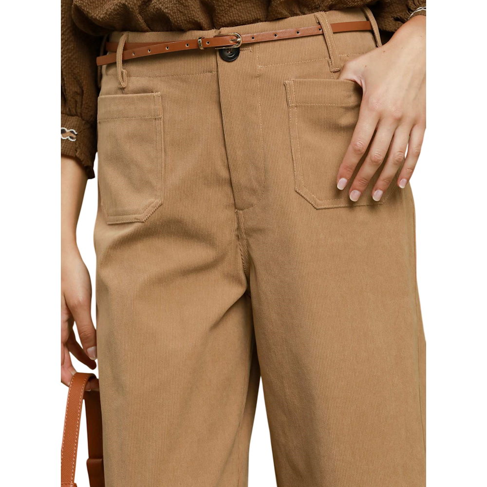 Close-up of high-waisted taupe corduroy pants with front patch pockets and a narrow brown leather belt.