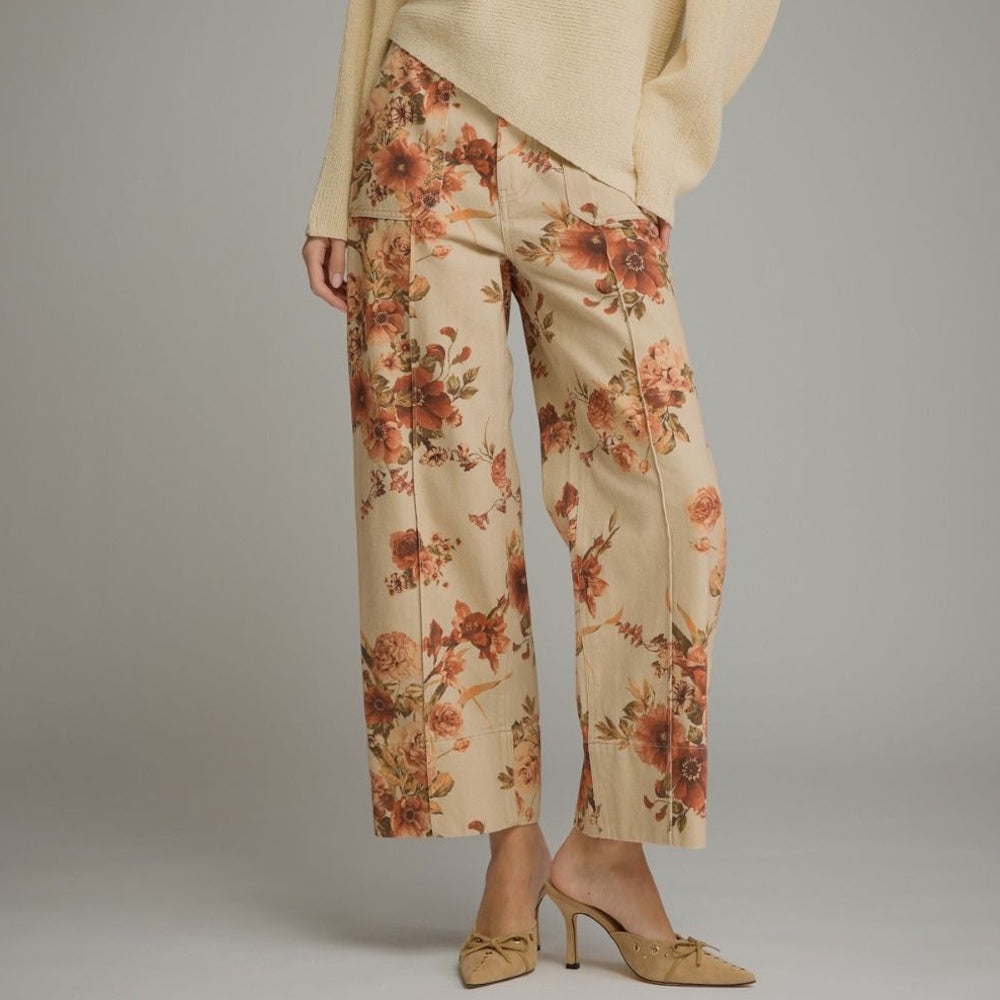 Taupe wide-leg pants featuring a rust floral print, utility front pockets, and seam details.