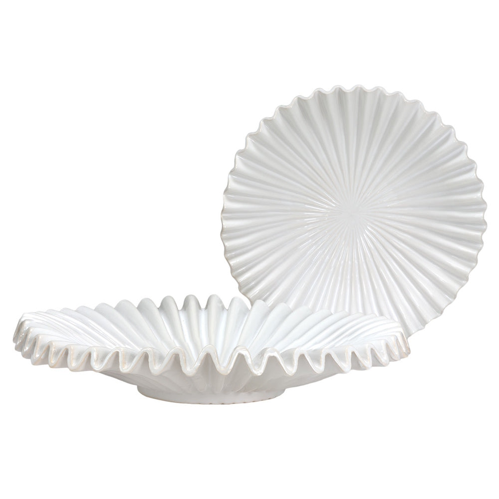 Two white ceramic fluted plates with ruffled edges, showcasing a sunburst texture on a clean white background.