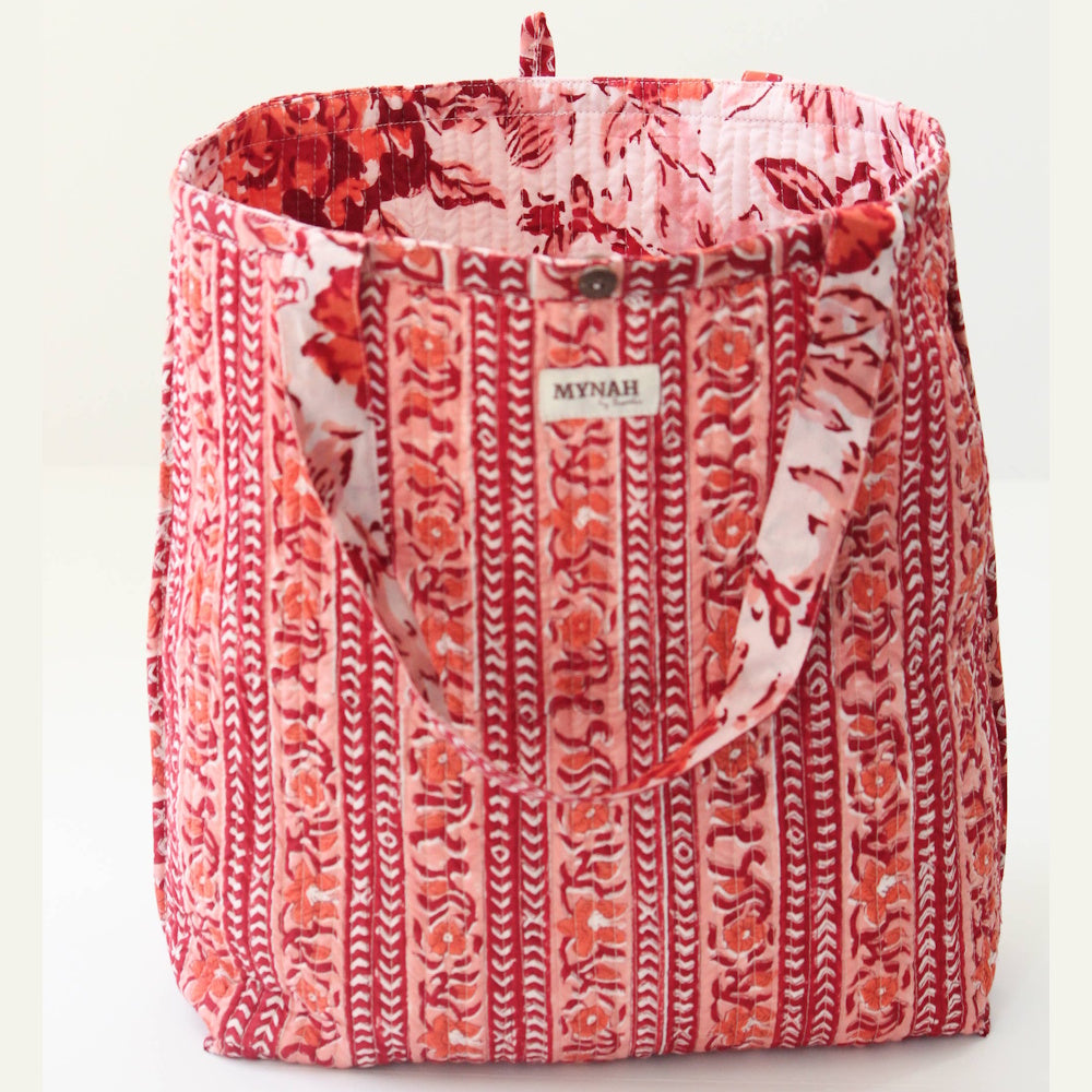 Reversible quilted tote bag featuring a terracotta geometric block print pattern and floral straps by MYNAH by Smitha.
