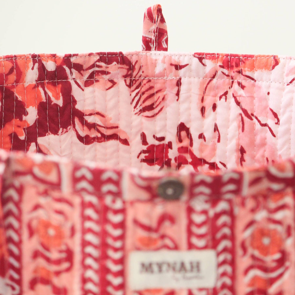Close-up of a MYNAH terracotta floral print reversible quilted tote bag showing intricate stitching and fabric detail.