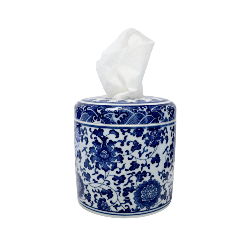 Blue and white chinoiserie ceramic tissue vessel with a floral pattern and a single white tissue dispensed from the top.