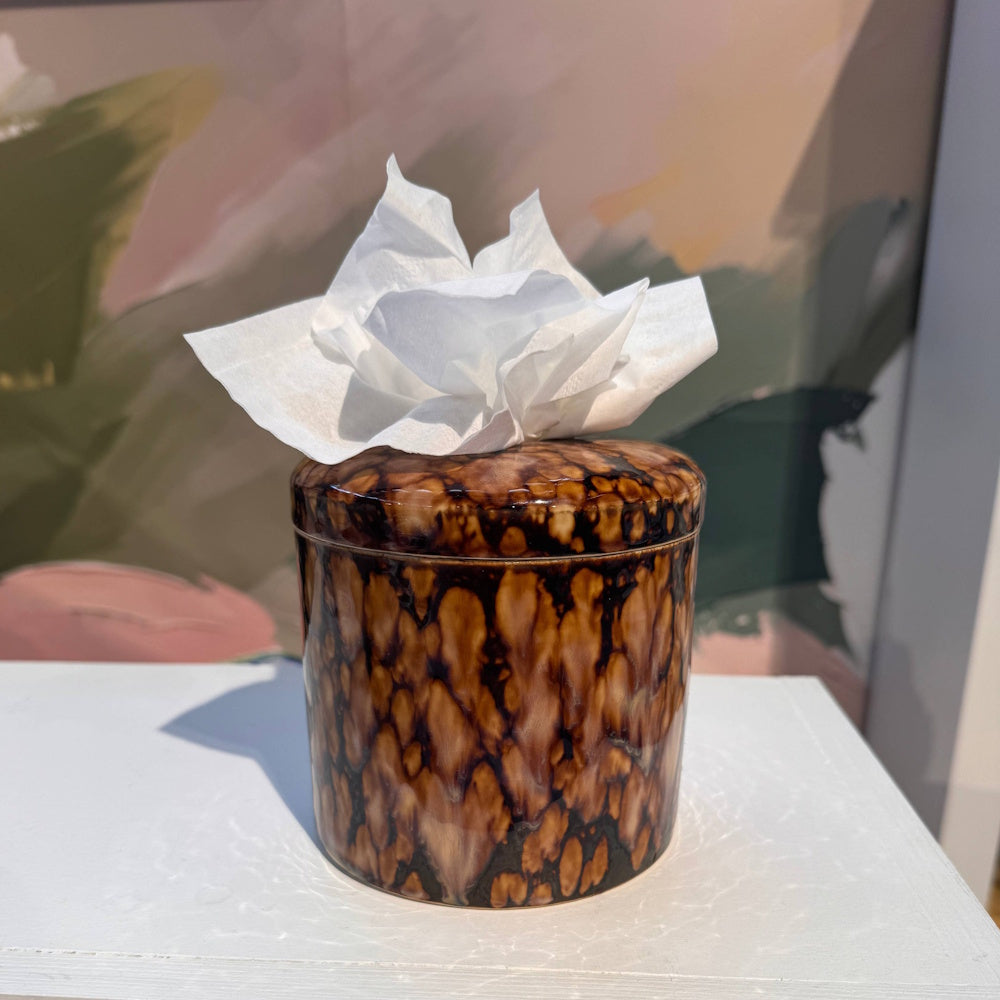 Tortoiseshell pattern tissue vessel holding tissues on a surface.