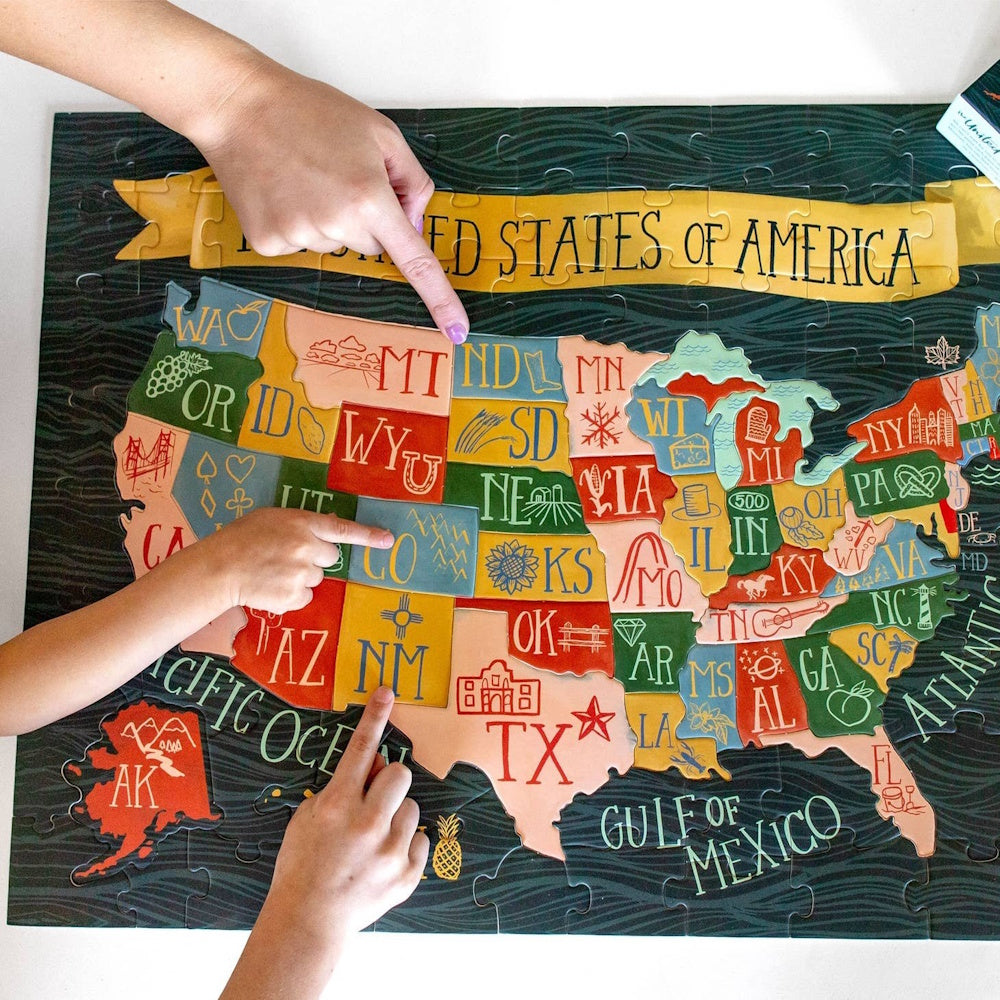 A completed puzzle of the United States map with three hands pointing to Montana, Colorado, and New Mexico.