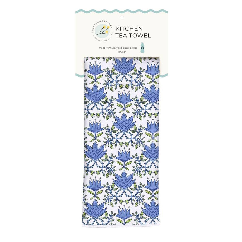 A white kitchen tea towel with a blue and green floral pattern, attached to its paper header card.