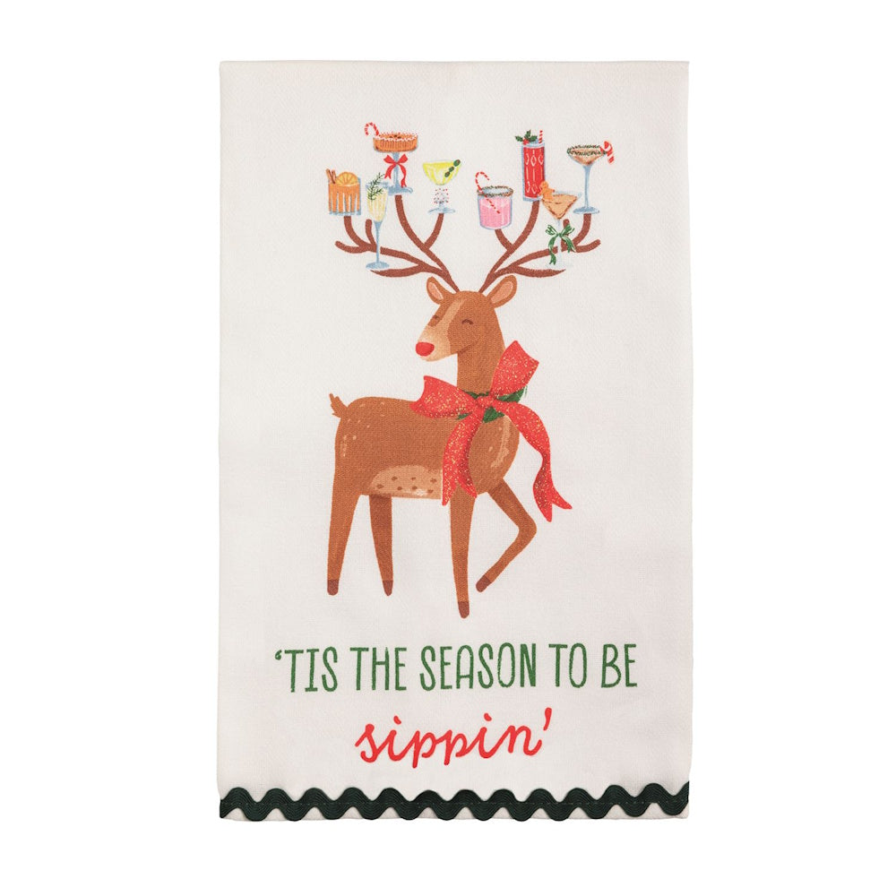 White tea towel featuring a reindeer balancing holiday cocktails on its antlers and "Tis the season to be sippin'" text.
