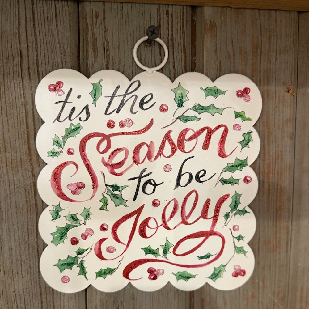 White metal square hanging sign featuring Tis the Season to be Jolly text, front view on wood wall.