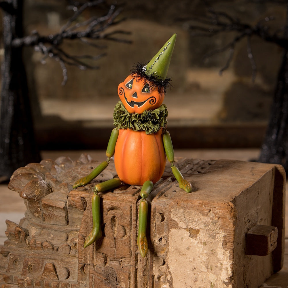Vintage Halloween pumpkin figurine with green limbs and a party hat that says TREATS.