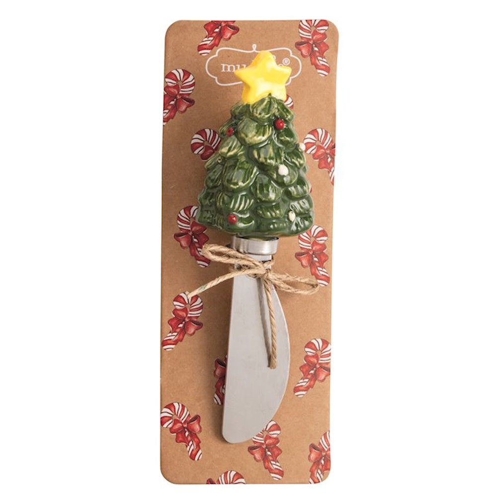 Cheese spreader with a ceramic Christmas tree handle on a ribbon-patterned backing card.