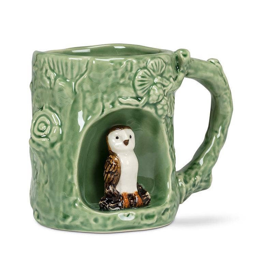 Green ceramic tree trunk mug featuring a small barn owl figurine perched inside a hollow opening.