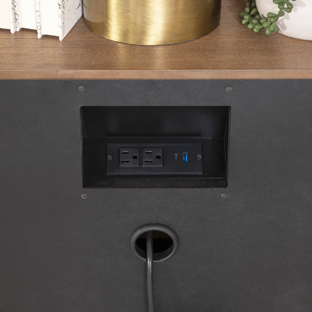 Built-in power outlet with USB ports and cable management hole on black furniture back panel.