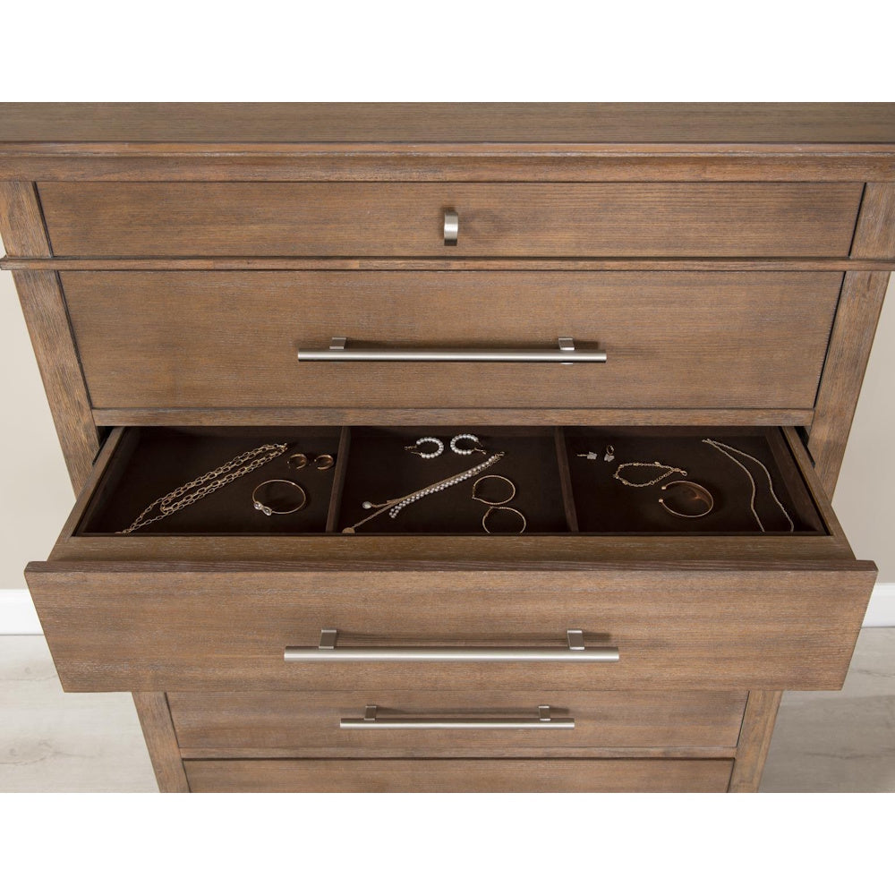 Wooden dresser with open jewelry drawer organizer, gold necklaces, and bracelets.