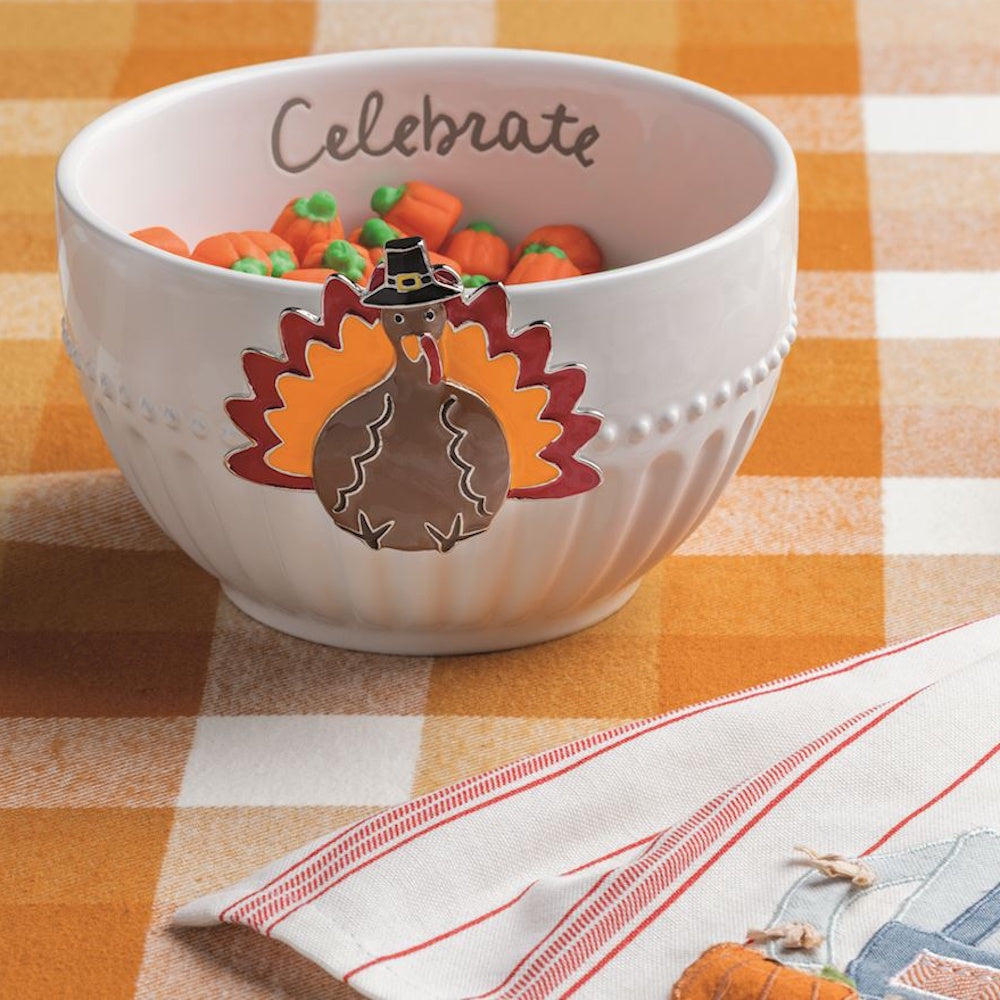 Mud Pie Thanksgiving turkey charm attached to a white ceramic bowl filled with mini pumpkin candies.
