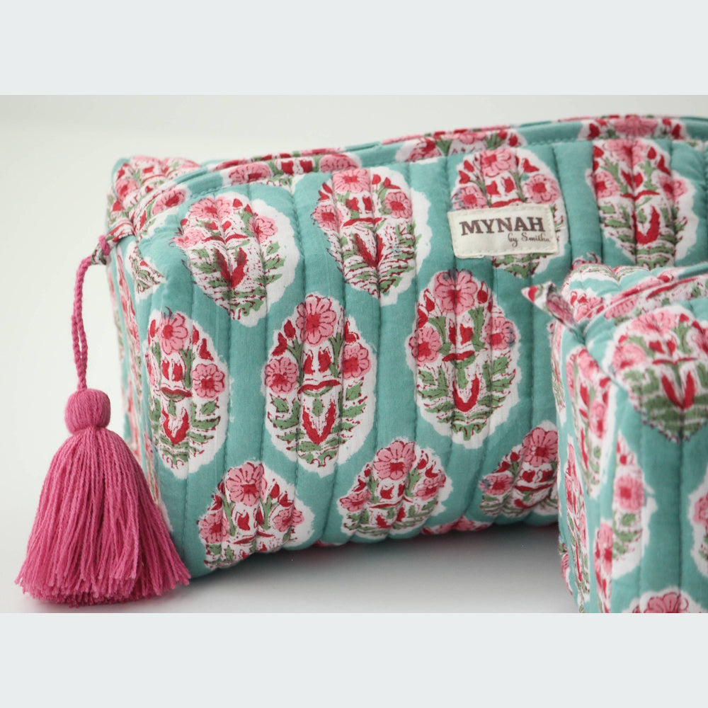 Turquoise floral quilted zipper pouch by MYNAH with a pink tassel and block-print flower pattern on a white background.
