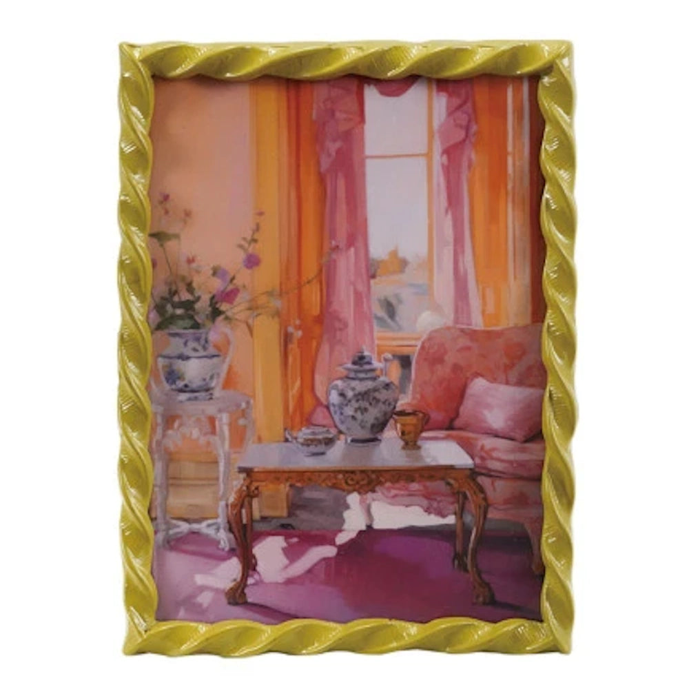 Decorative twisted yellow picture frame showcasing a painting of a pink living room with ginger jars and a marble table.