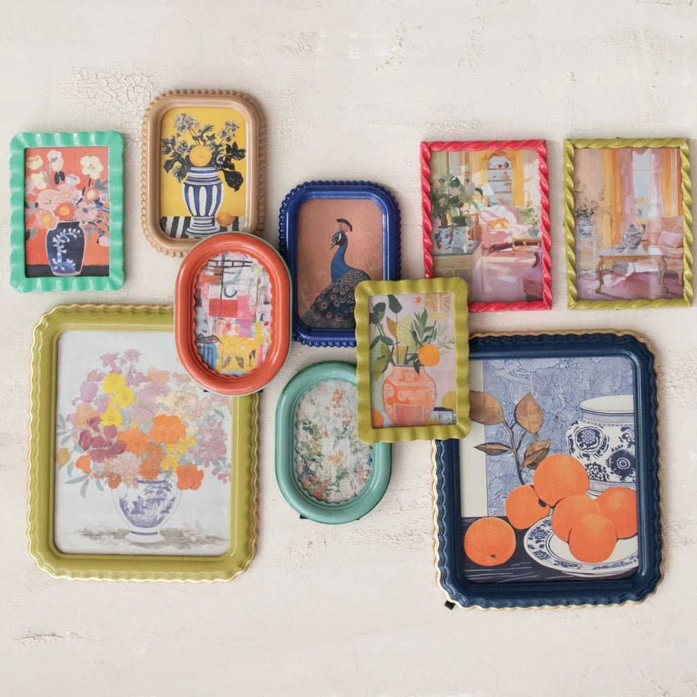 Gallery wall of colorful MDF photo frames with scalloped and twisted edges, displaying vibrant botanical and animal art.