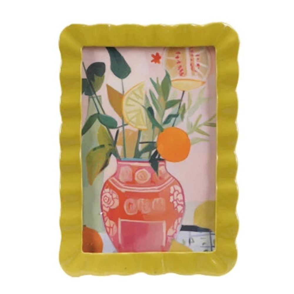 Colorful citrus art print in a yellow scalloped frame featuring a pink floral vase with lemons and oranges on pink.