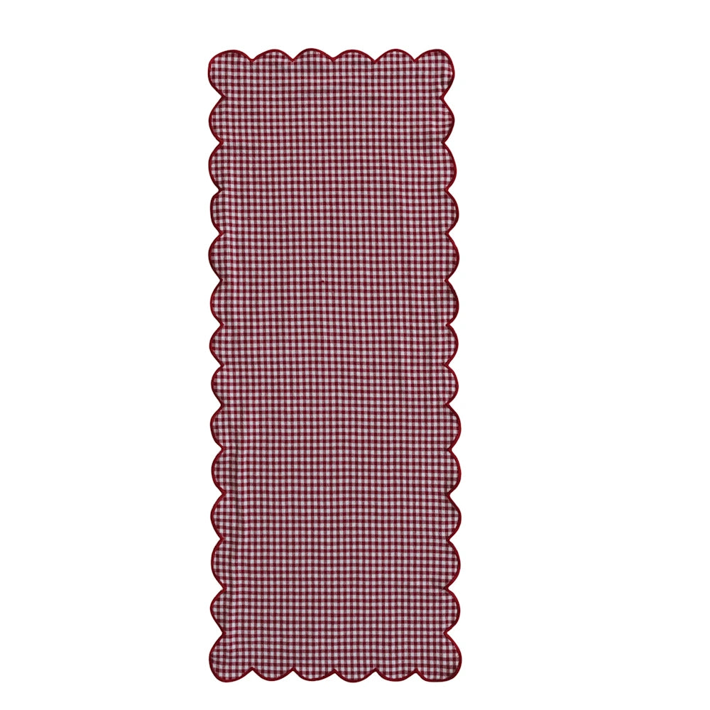 Red and white gingham checkered table runner featuring red scalloped trim.