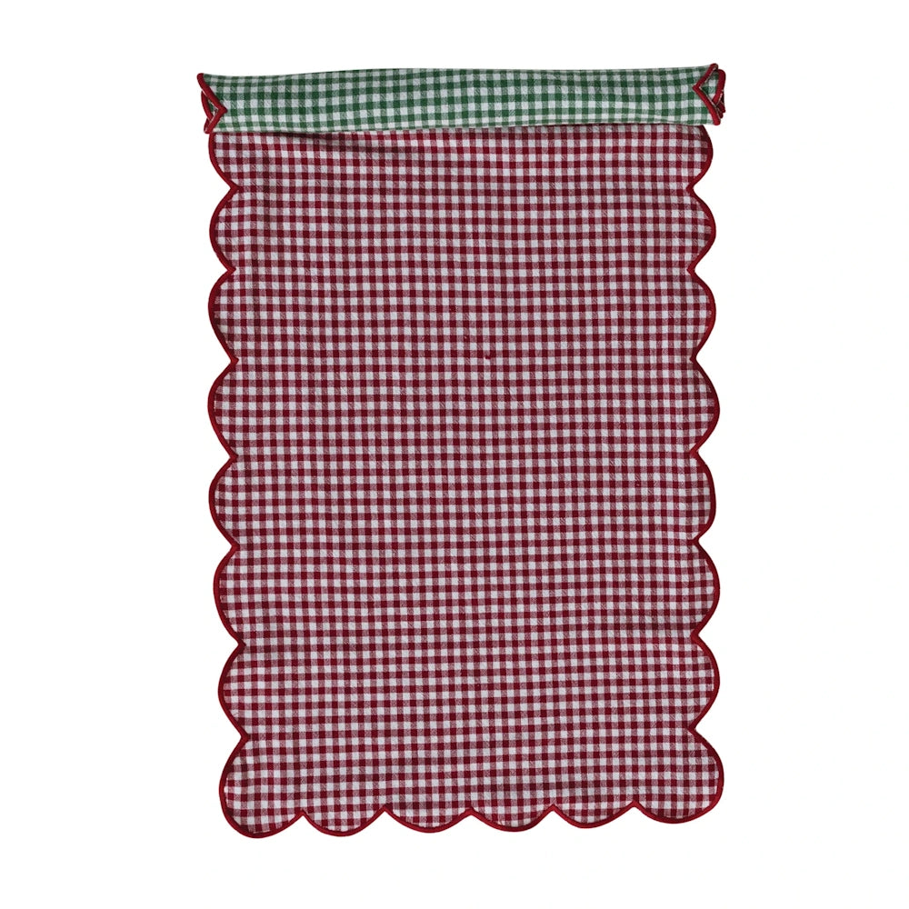 Reversible red and green gingham table runner with scalloped edges folded to show both patterns.