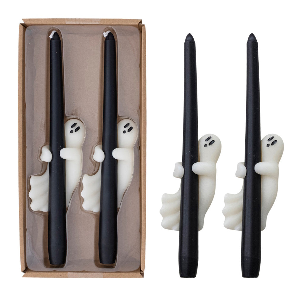 Pair of black taper candles featuring small white ghost figures, packaged in a cardboard box.