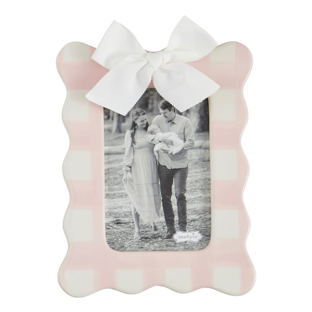 Pink gingham scalloped ceramic picture frame with a white ribbon bow and a black and white family photo.