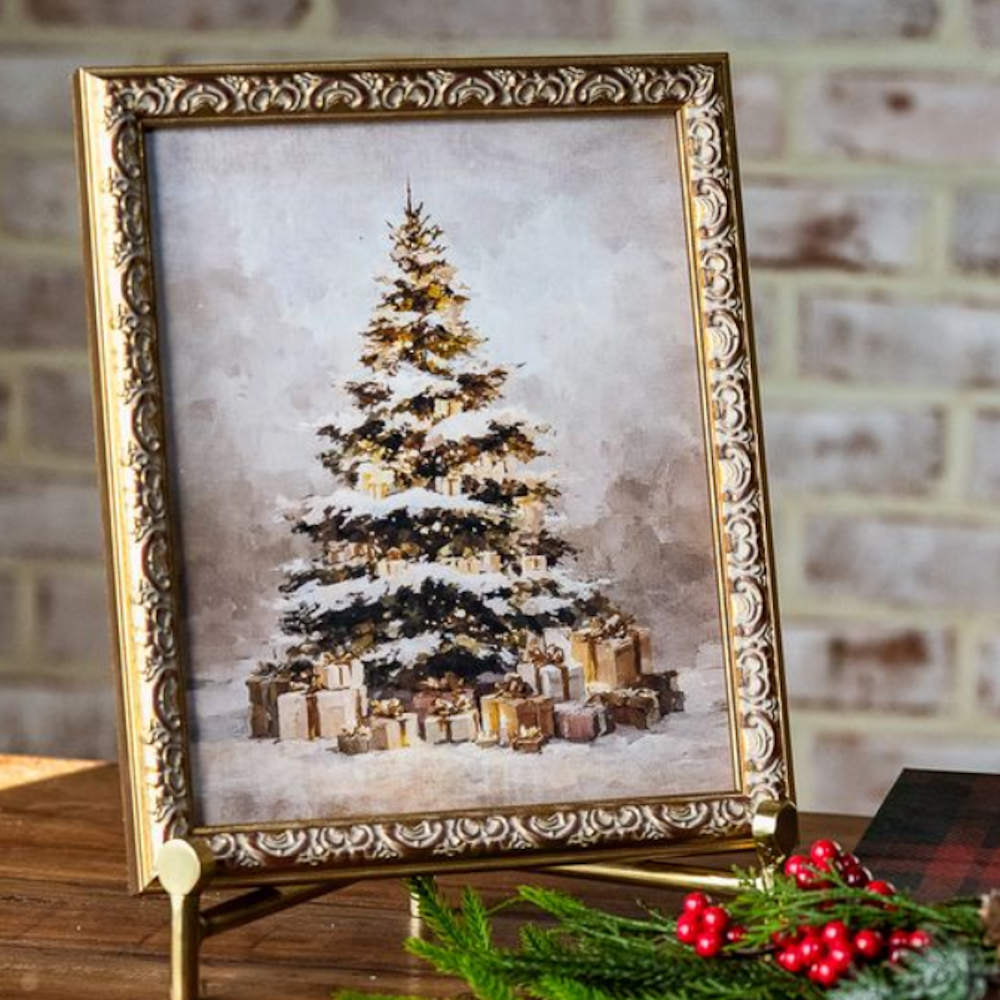 Framed art print of a snow-covered Christmas tree with gifts, displayed in an ornate gold frame.