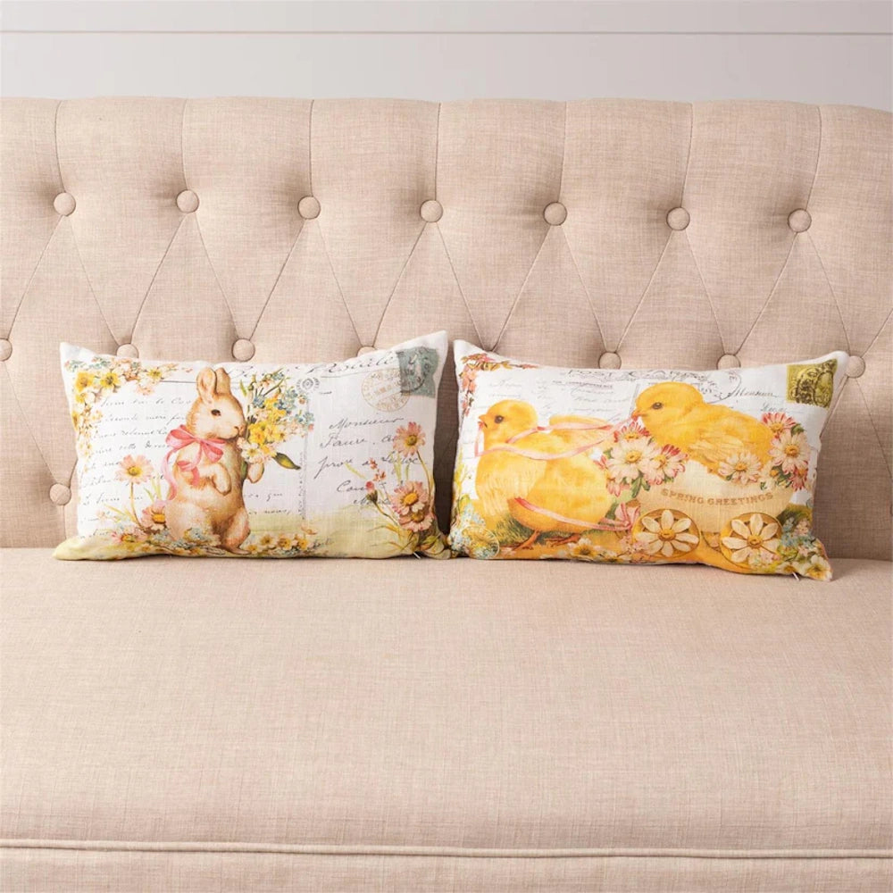 Two Easter-themed vintage postcard pillows with a bunny and yellow chicks on a tufted beige sofa.
