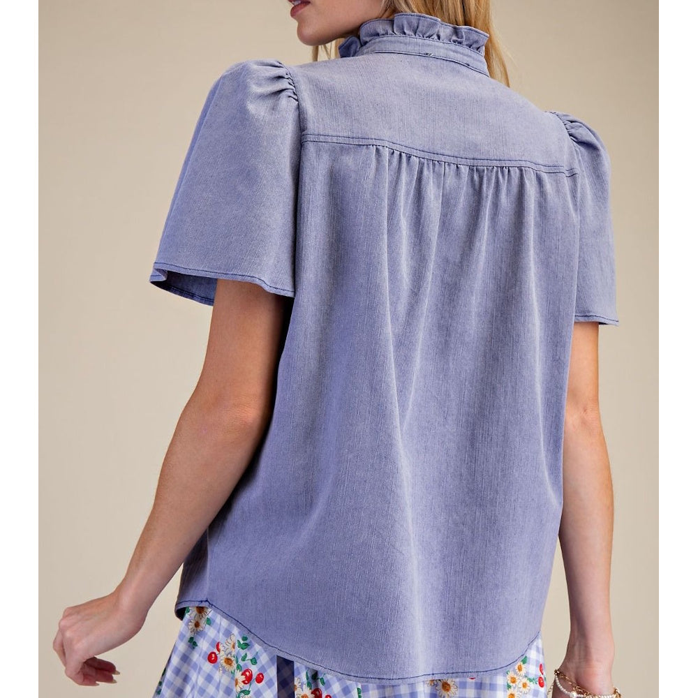 Back view of washed blue chambray top featuring gathered back yoke and ruffled high collar.
