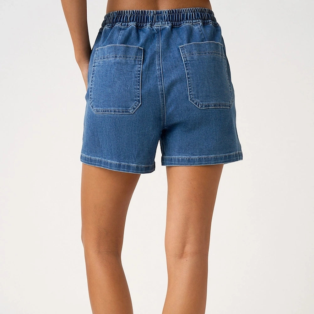 Back view of blue denim shorts featuring an elastic waistband and two large square patch pockets.