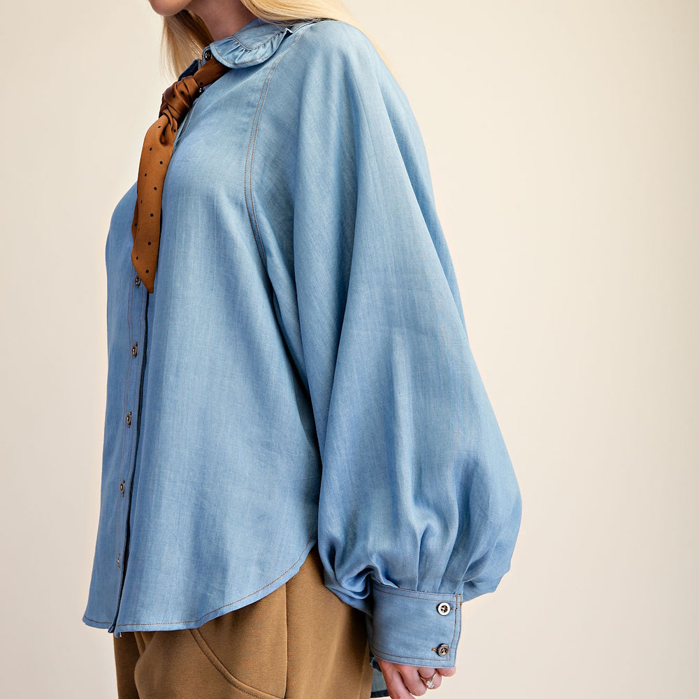 Side profile of light blue washed denim chambray shirt with voluminous billowy sleeves.