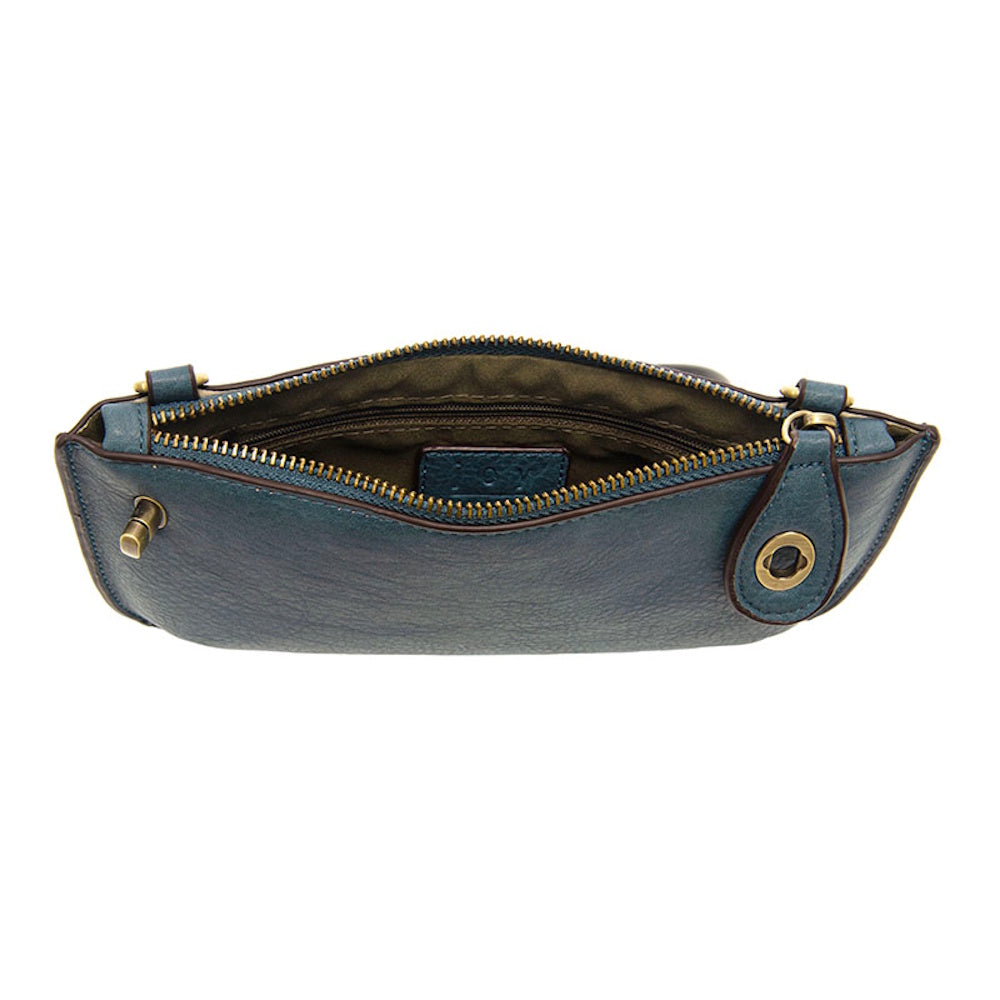 Open view of a blue washed denim mini crossbody clutch with a top zipper and brass hardware on a white background.