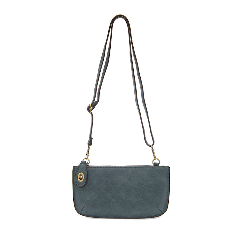 Washed denim mini crossbody bag with adjustable shoulder strap and brass hardware on a white background.