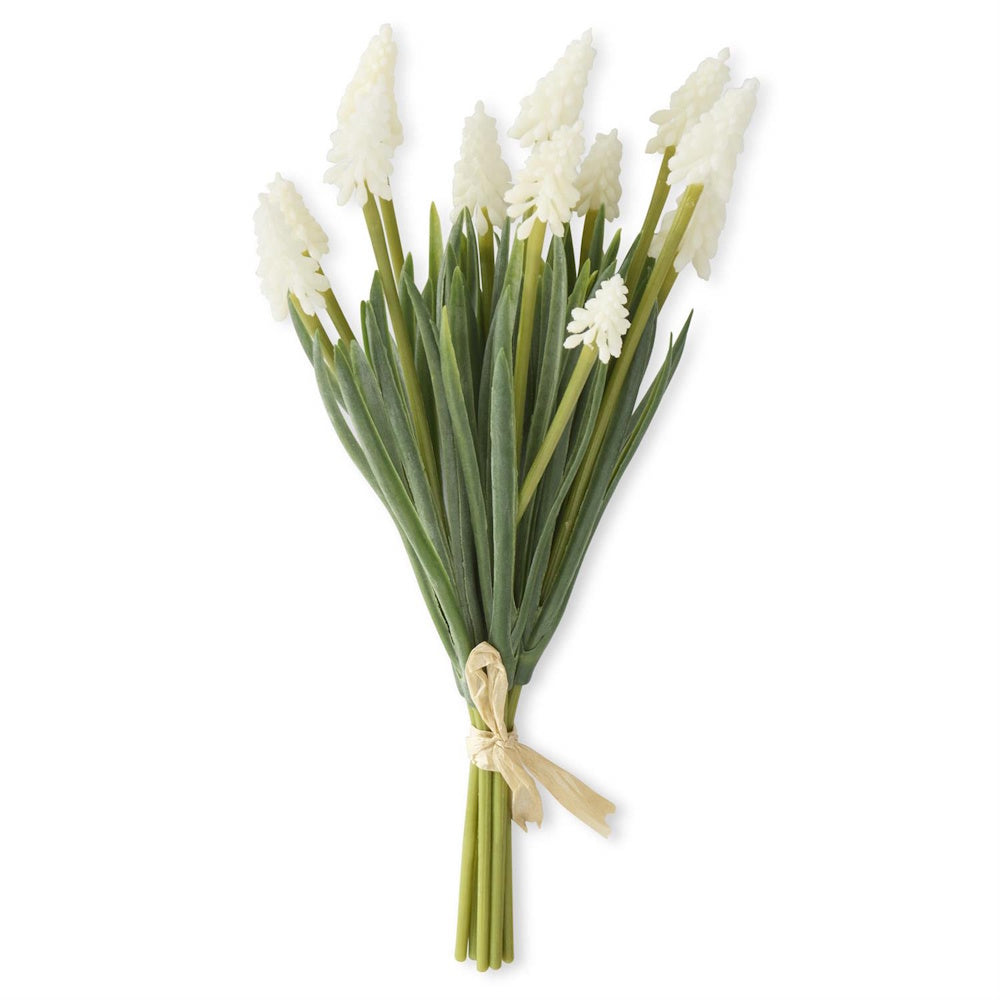 Bundle of artificial white grape hyacinth flowers with green stems and raffia bow.