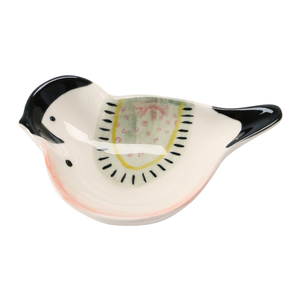 A hand-painted, bird-shaped stoneware dish in cream with black accents and a patterned green and yellow wing.