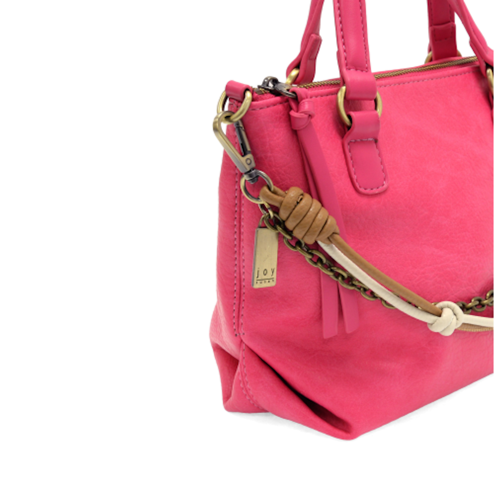 Hot pink pebbled leather handbag with brass chain detail and tan and cream knotted cord accents.