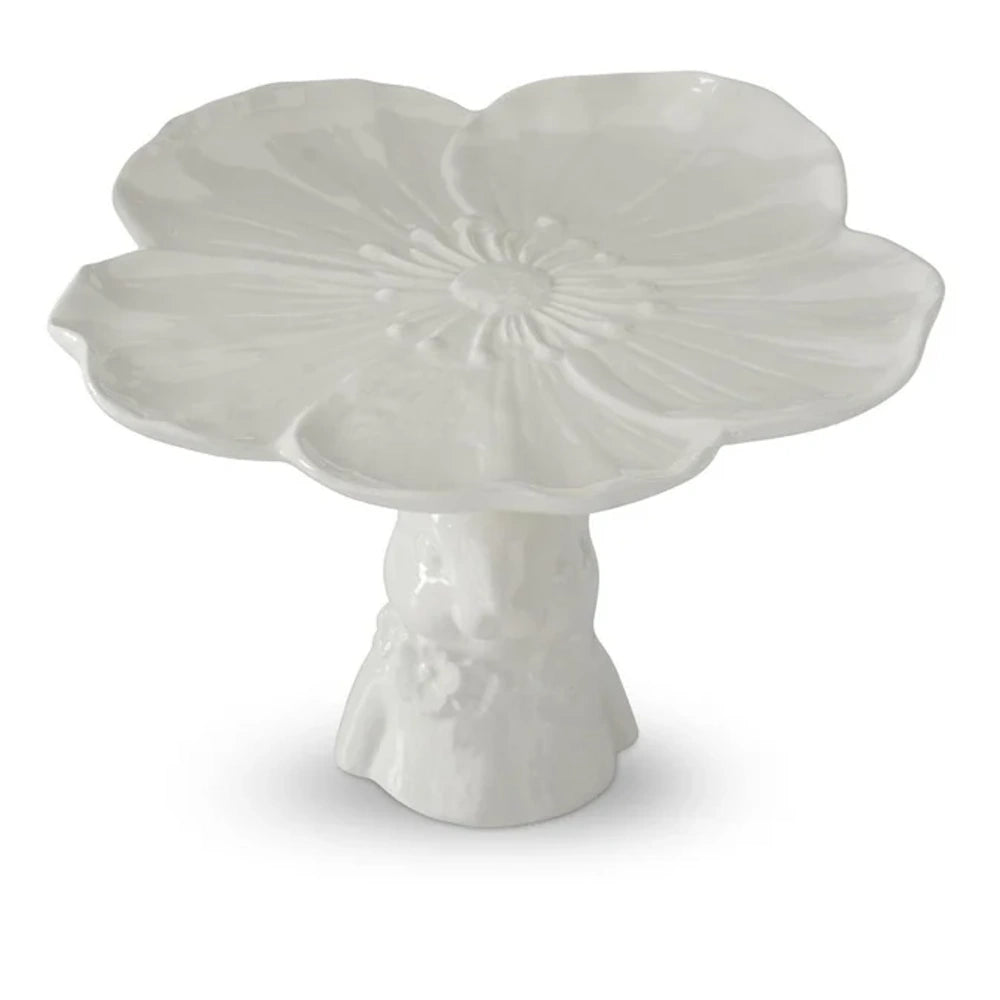 A white ceramic pedestal cake stand with a flower-shaped top and a rabbit base.