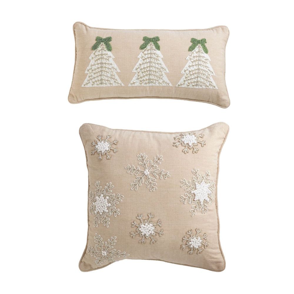 Beige pillows with white beaded Christmas trees and snowflakes against a white background.