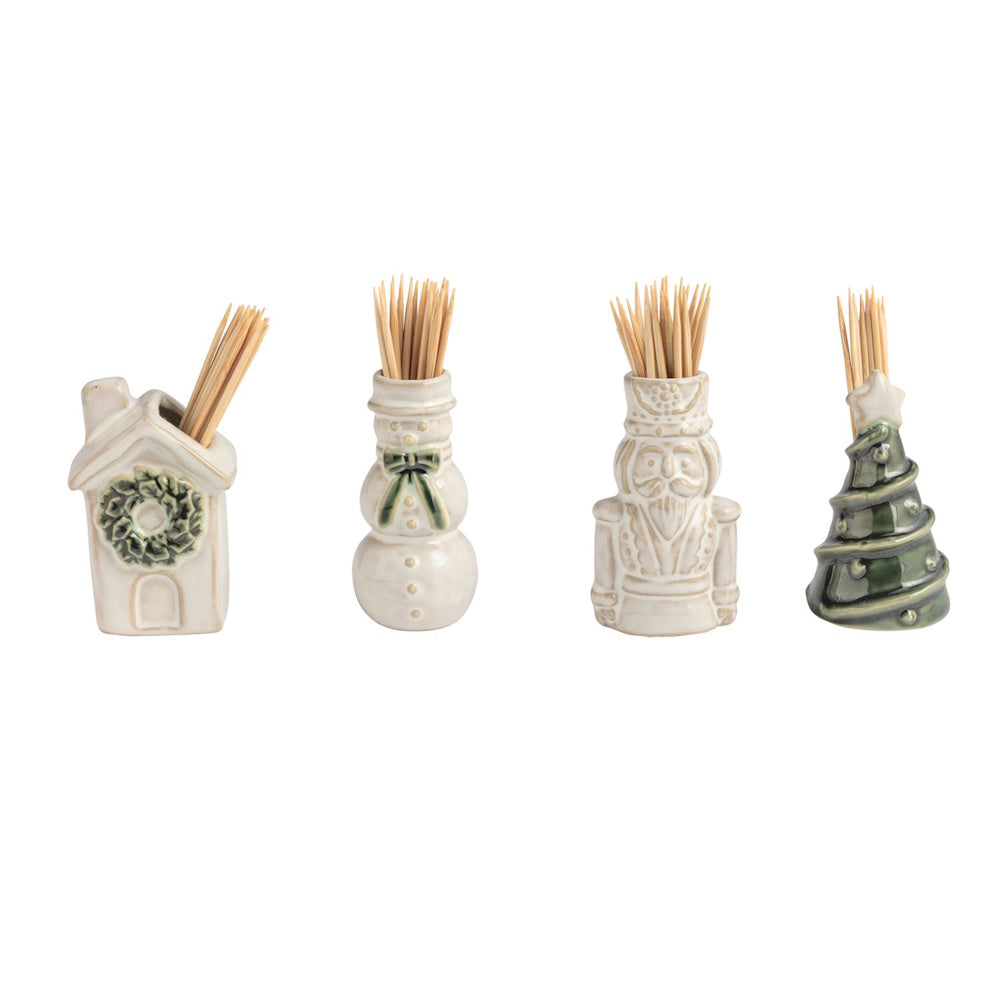 Four ceramic holiday toothpick caddies shaped like a house, snowman, nutcracker, and tree.