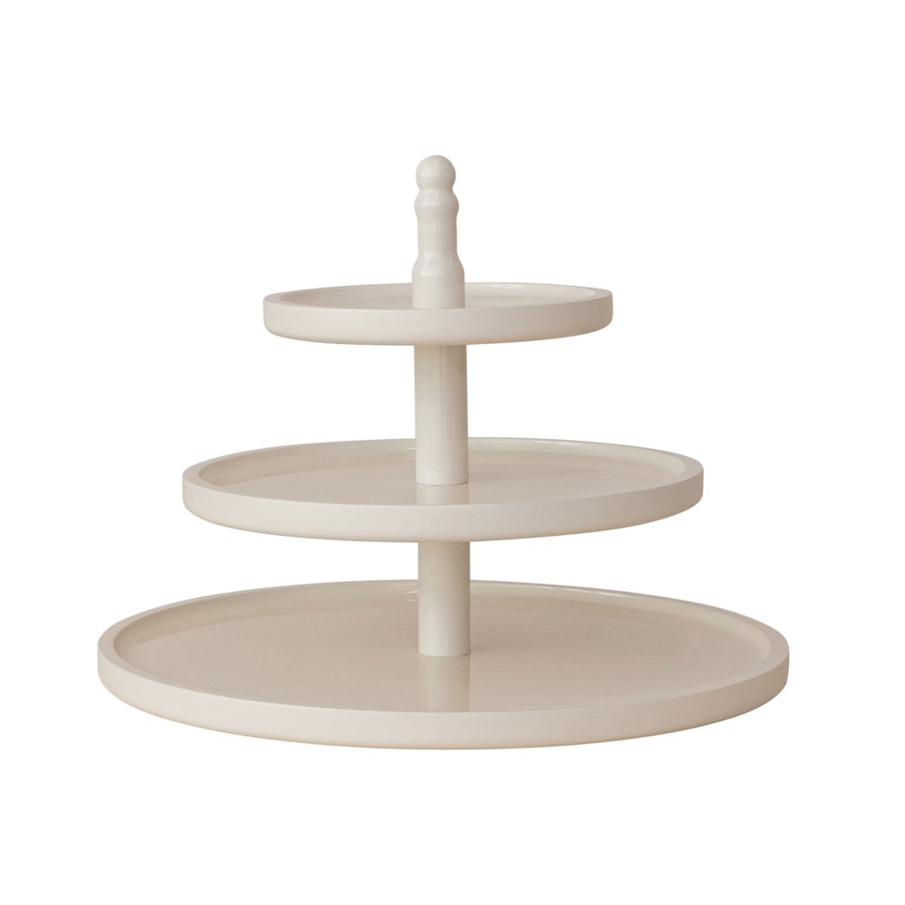 A glossy, off-white three-tier serving tray with round plates and a central spindle handle.