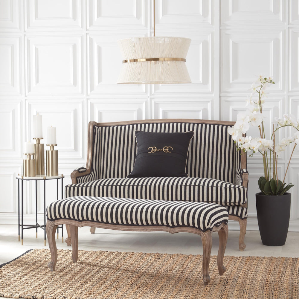 Elegantly styled living space featuring black-and-white striped seating and white orchid decor.