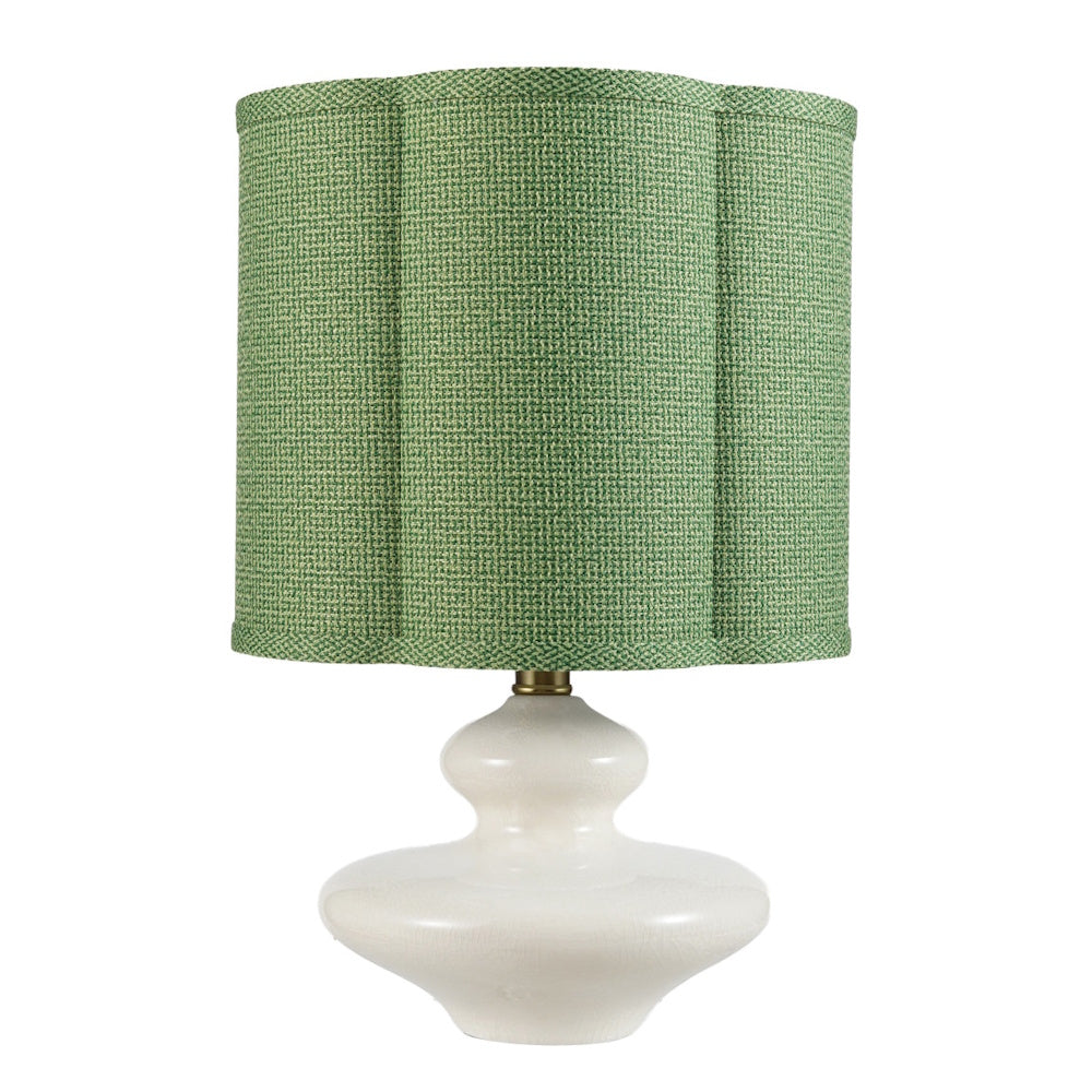 White stoneware table lamp featuring a textured, scalloped green fabric shade for modern home decor.