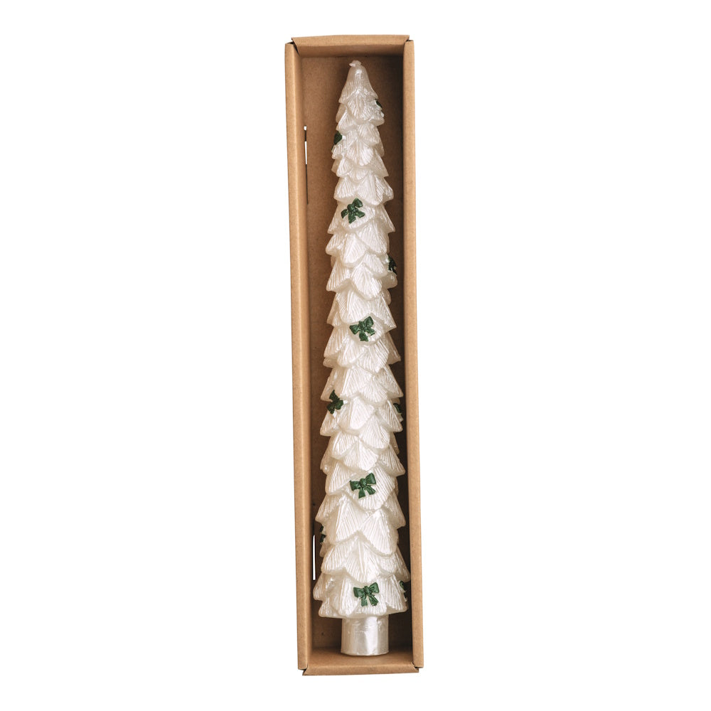 White tree-shaped wax candle with green bow accents in a cardboard box, viewed from above.