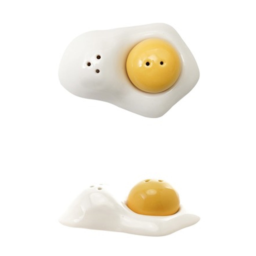 White and yellow stoneware salt and pepper shakers shaped like a fried egg with a removable yolk.