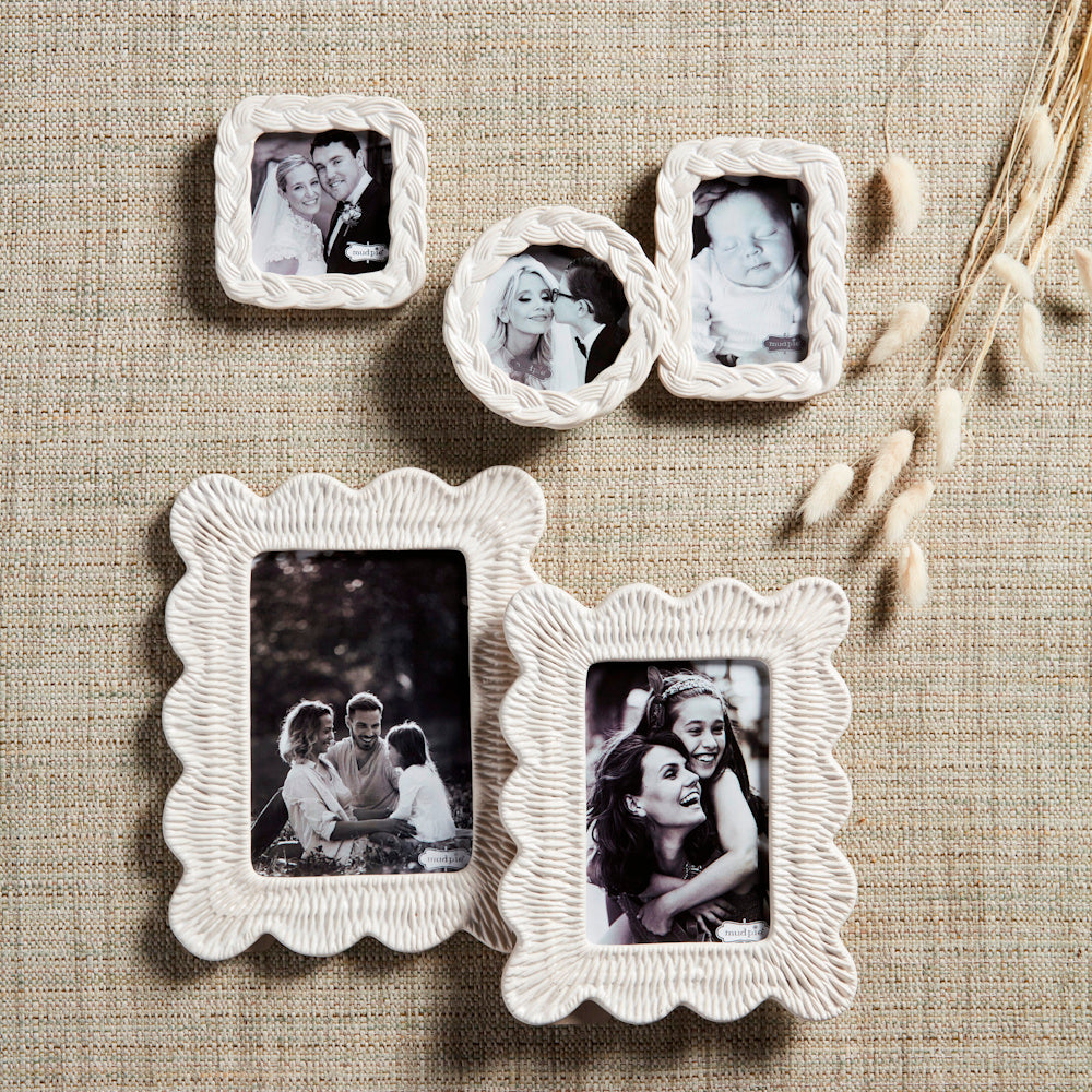 White textured stoneware picture frames with woven wicker patterns in various shapes on a neutral burlap background.