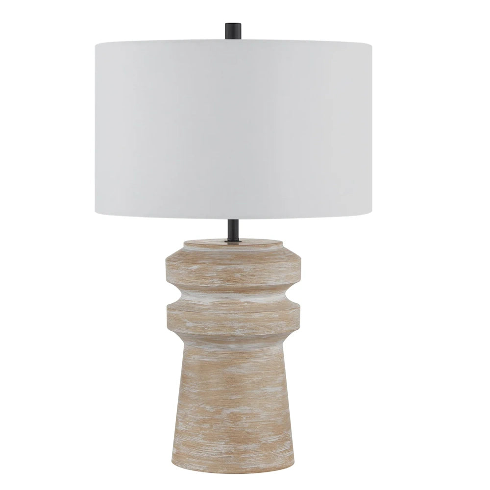 Distressed natural wood table lamp with sculpted base, white drum shade and black metal accents.