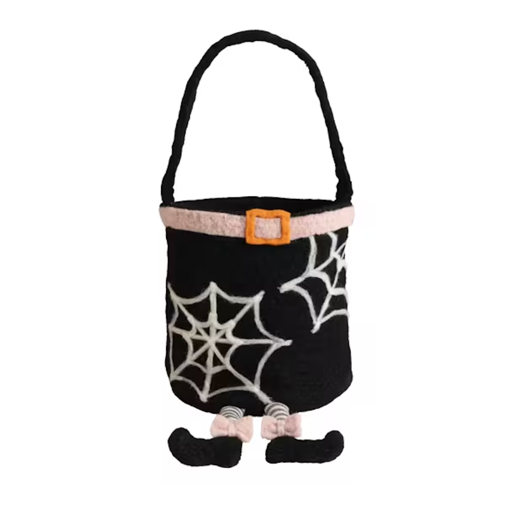 Black witch felt treat bucket decorated with white spiderwebs, a pink belt, handle, and dangling striped legs.