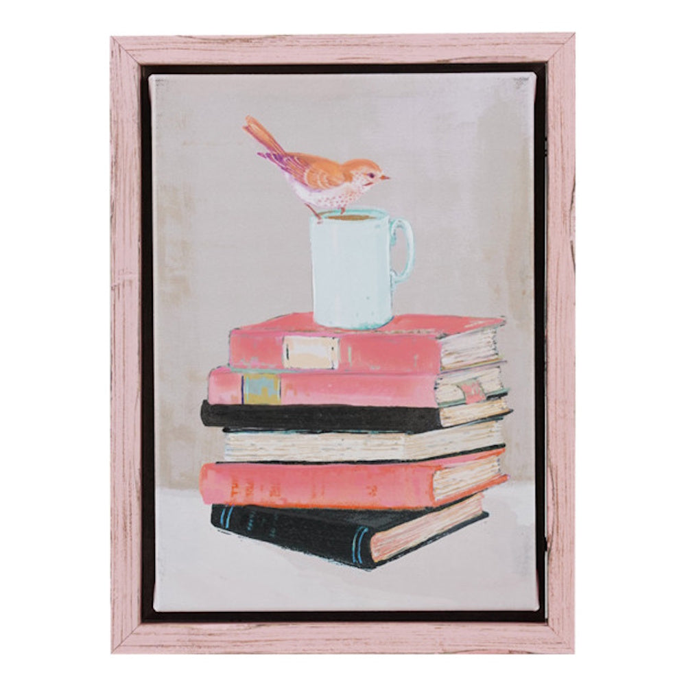 A robin perched on a coffee mug atop a stack of vintage books, in a distressed pink wood frame.