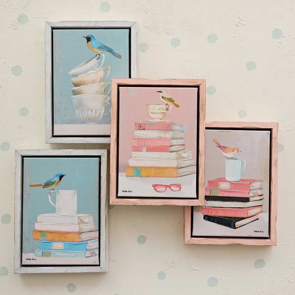 Set of four framed bird and book canvas wall art pieces displayed on a polka dot wall for whimsical home decor.