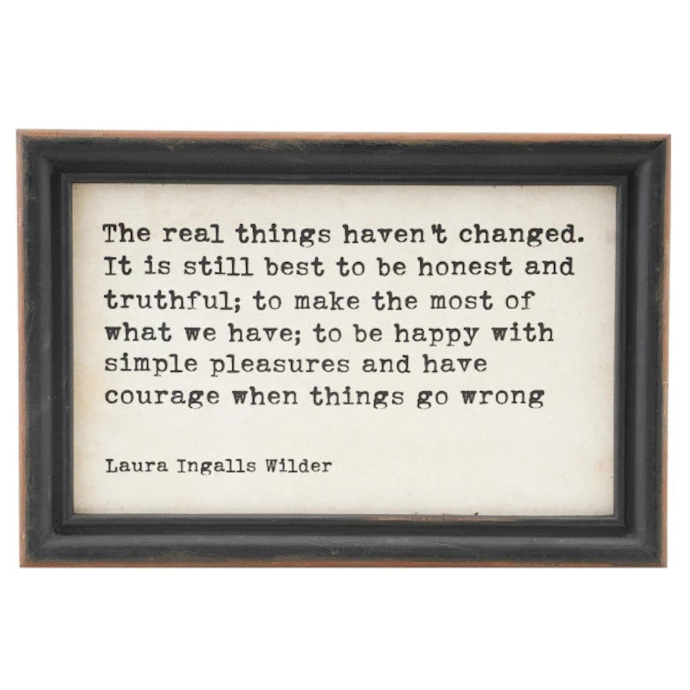 Framed Laura Ingalls Wilder quote on rustic paper about honesty, simple pleasures, and courage in a dark wood frame.